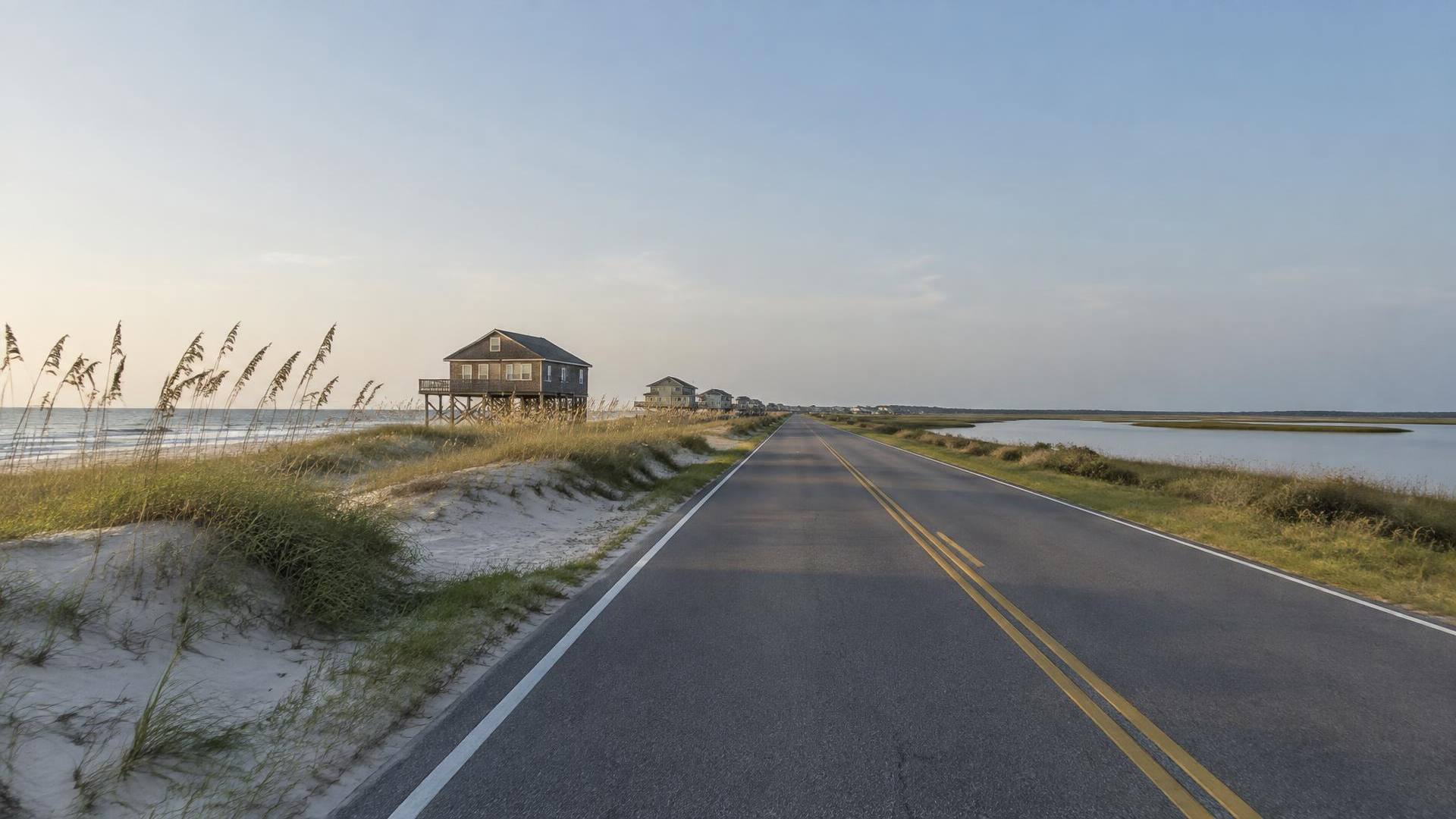 NC Highway 12 running between sea oat dunes and the Pamlico Sound on Hatteras Island